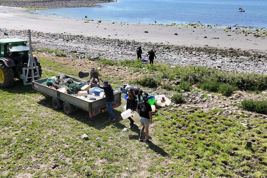A drone shot capturing MindWorks and Suzuki colleagues collecting rubbish during a beach clean in Scotland.